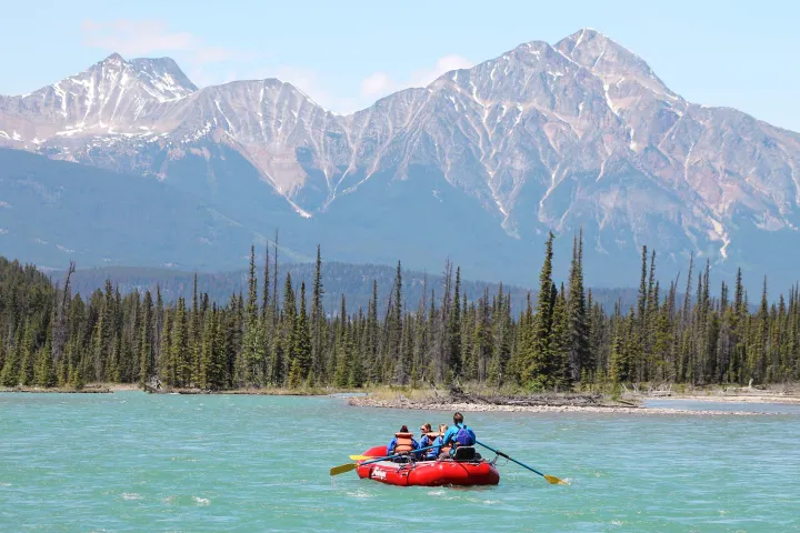 a small boat in a body of water with a mountain in the background